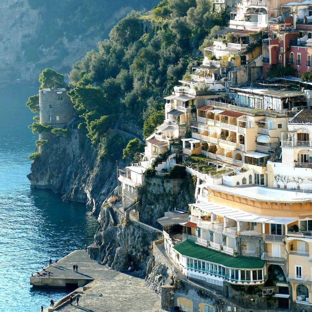 Pastel houses overlooking a small harbor on the Amalfi Coast at dusk.