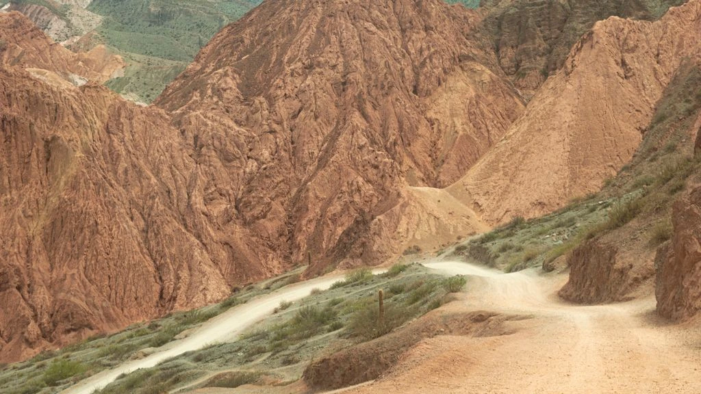 Dirt road through arid Patagonian mountains at golden hour